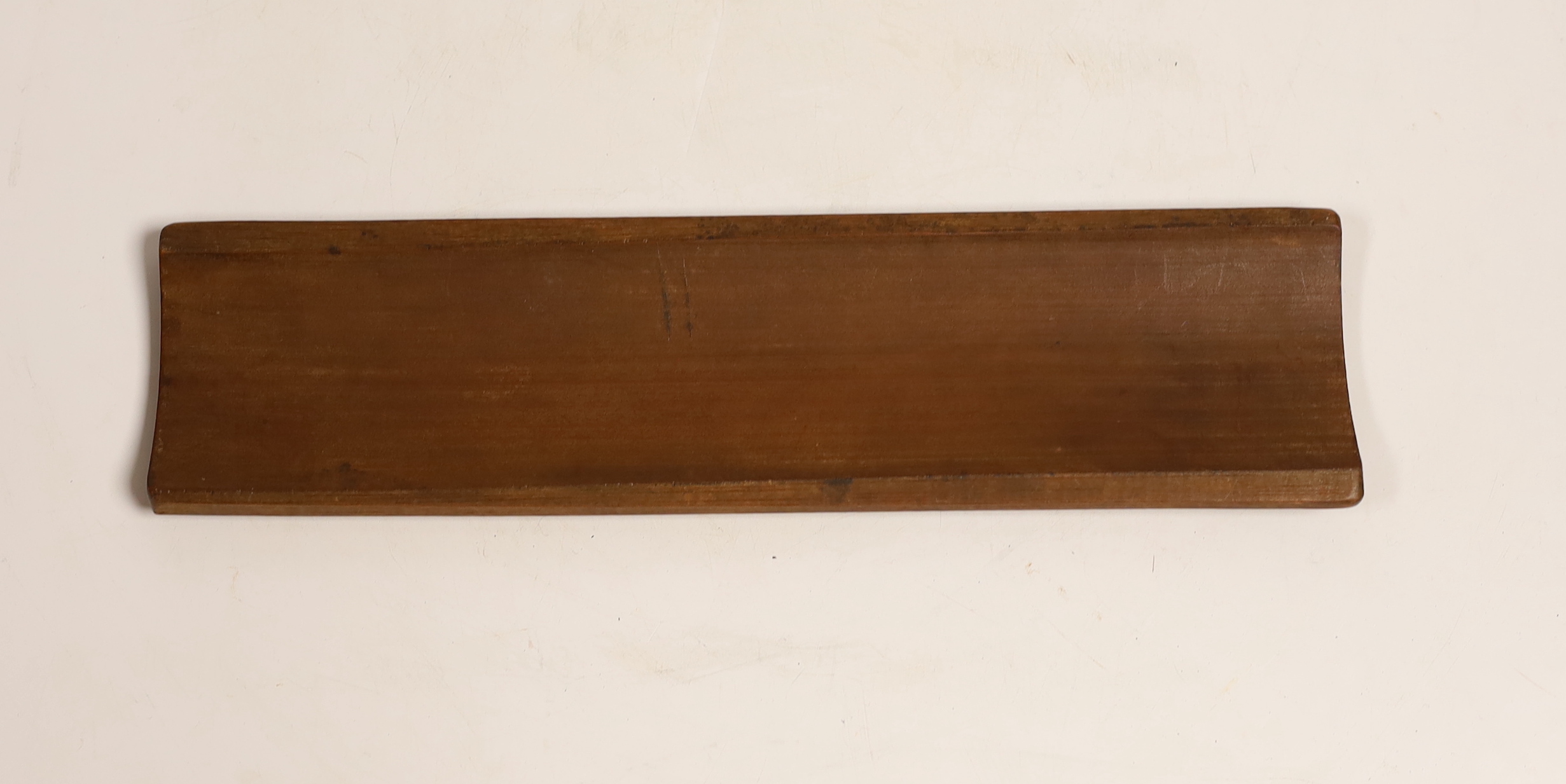 A Chinese bamboo inscribed wrist rest, carved in relief with columns of calligraphy, 30cm wide